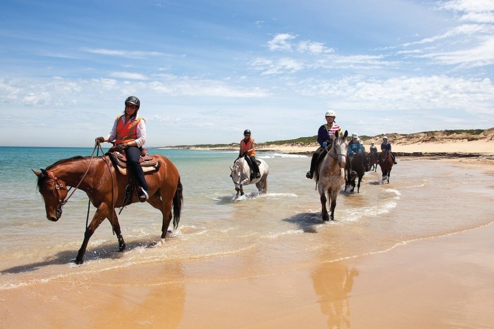 a man riding a horse on a beach