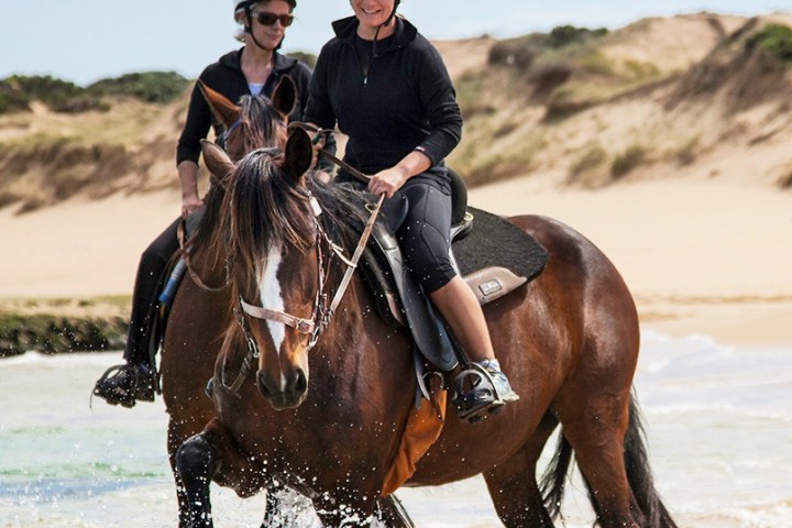a man riding a horse in a body of water