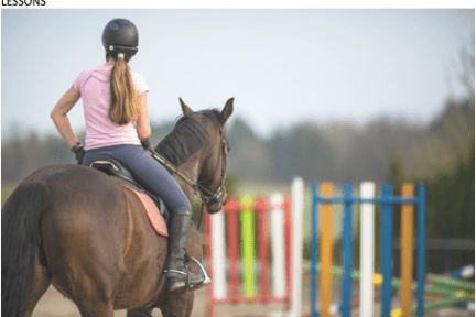 a person riding on the back of a brown horse